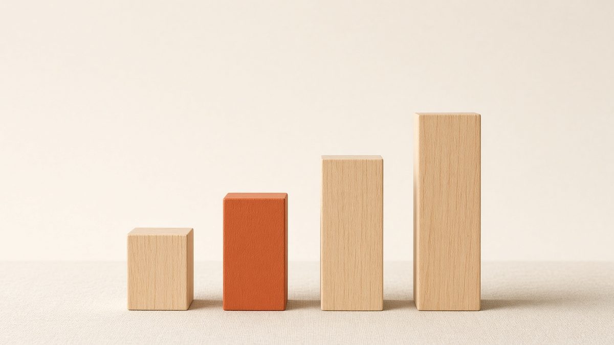4 timber blocks arranged in rising steps like a bar chart, the second block painted orange